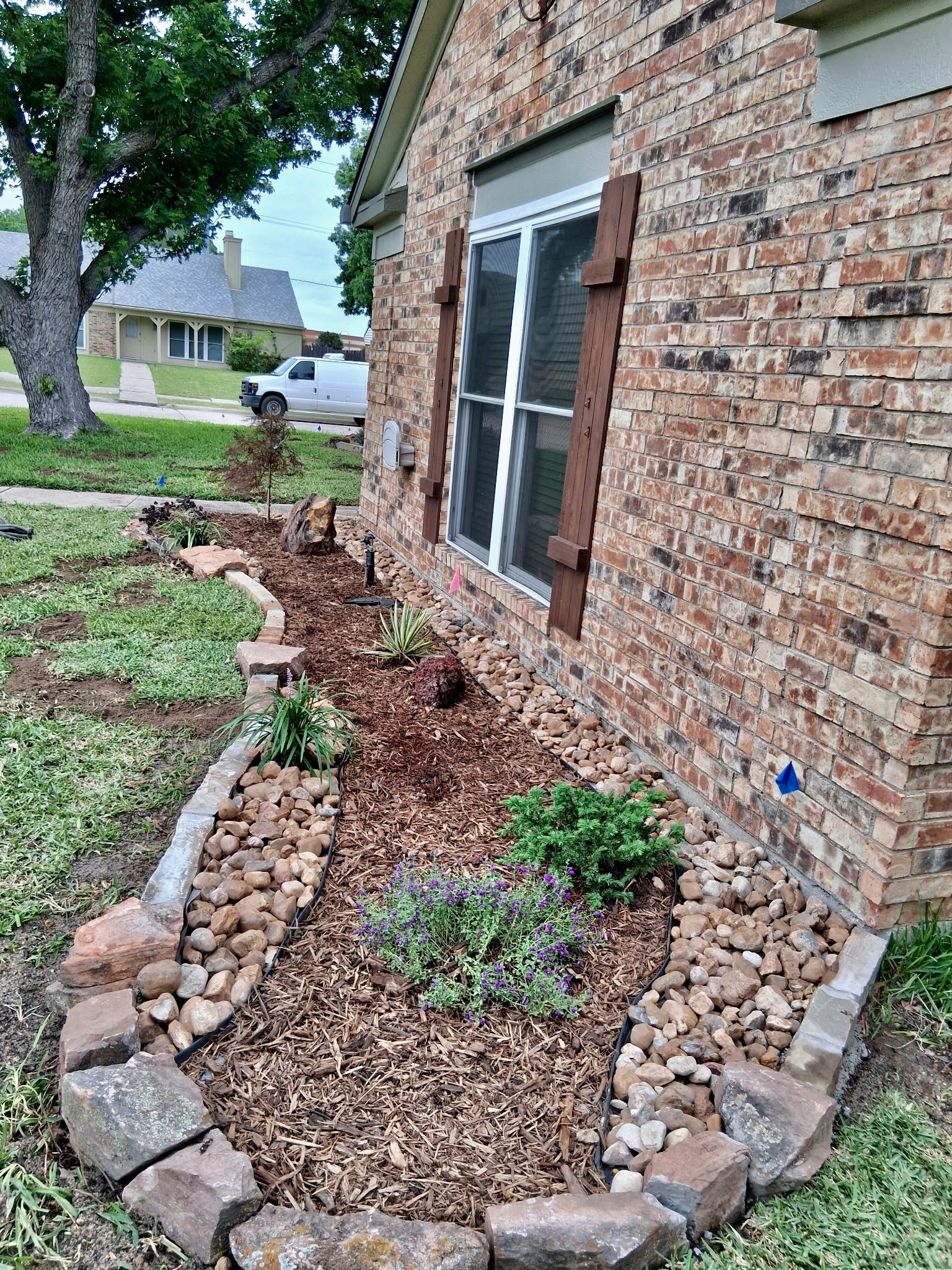 Curved flower bed with drainage edging in Garland, TX